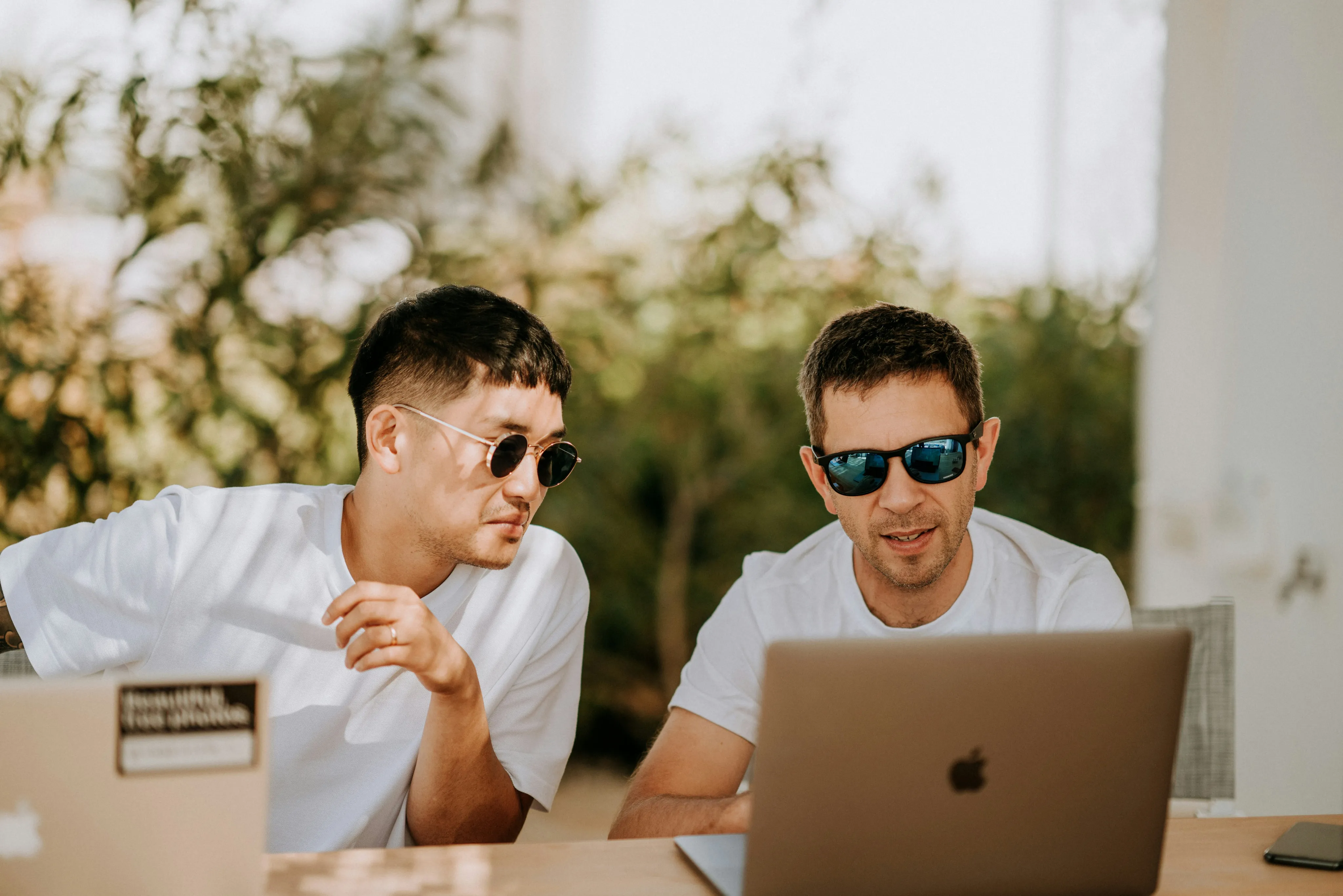 Two colleagues from a marketing agency looking at a laptop together outdoors